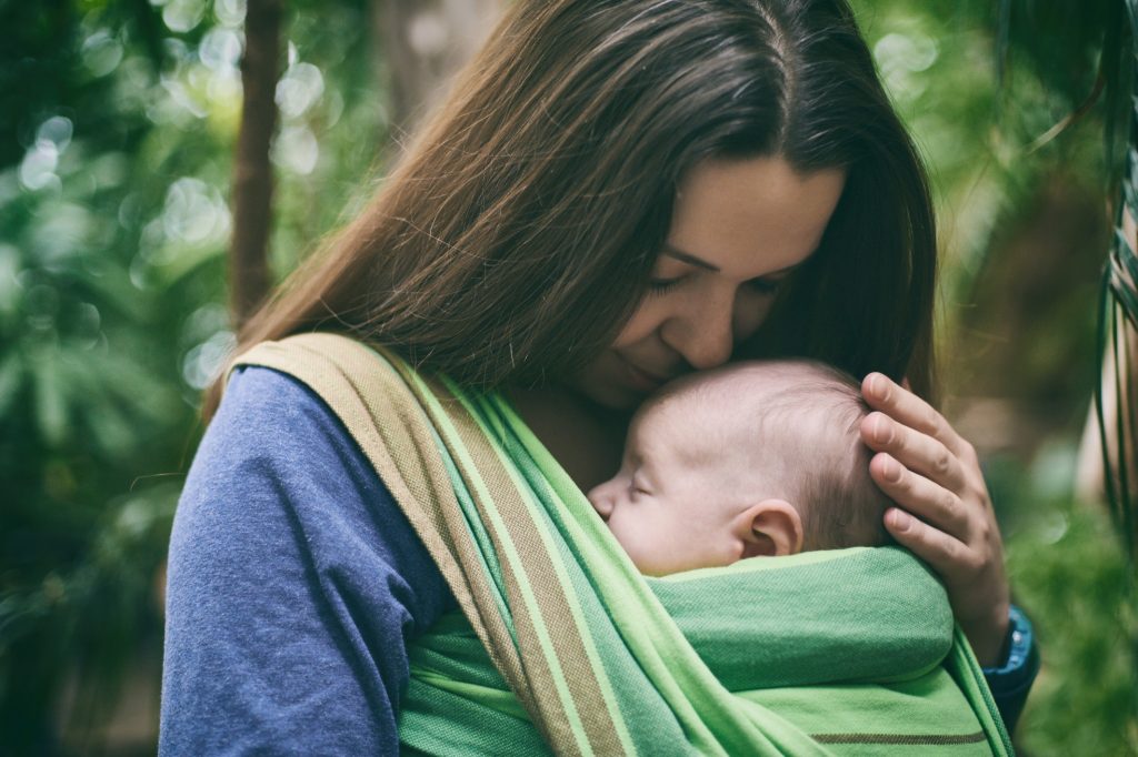 Image of a mother with her baby in a front wrap.